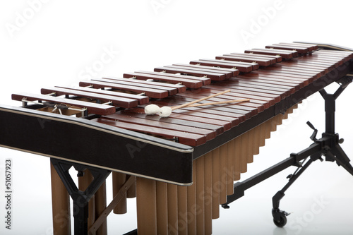 A brown wooden marimba on a white background