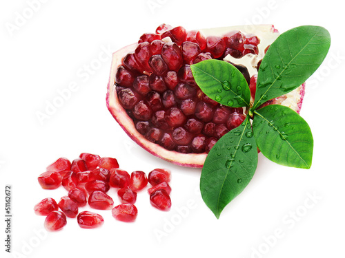 Part of pomegranate fruit with green leaves isolated on white ba