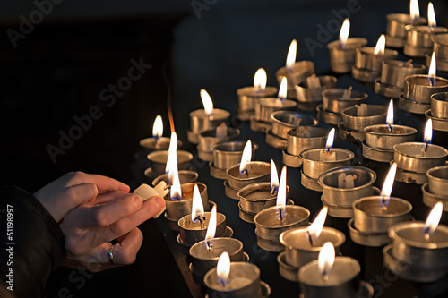 Encendiendo velas en una iglesia a modo de ofrenda.