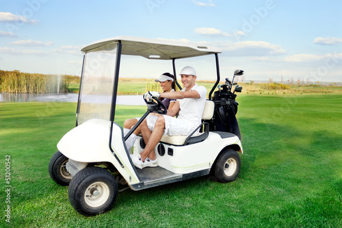 happy couple driving a golf-cart