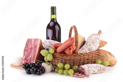 wicker basket with sausages, ham and wine