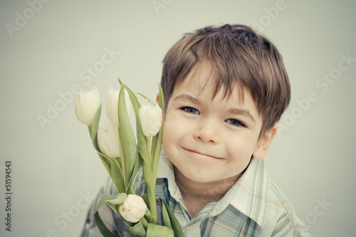 Uśmiechnięty chłopiec z tulipanami