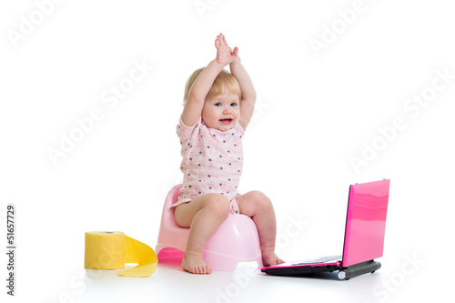 baby girl sitting on chamberpot with notebook