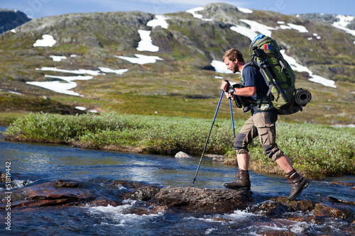 Wanderer beim überqueren von Stromschnellen in Norwegen