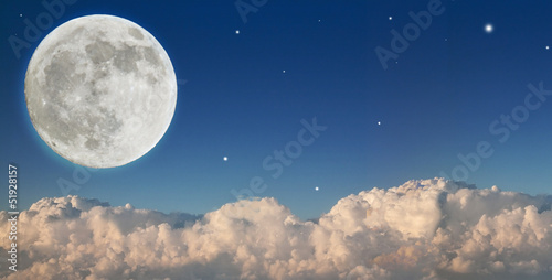 large moon above dark clouds