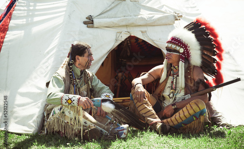 North American Indians sit at a wigwam