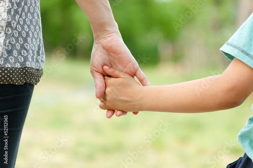 Mother holding a hand of her son