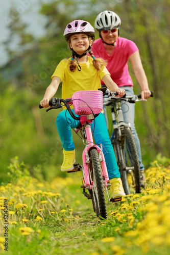 Bike riding - girl with mother on bike, active family concept