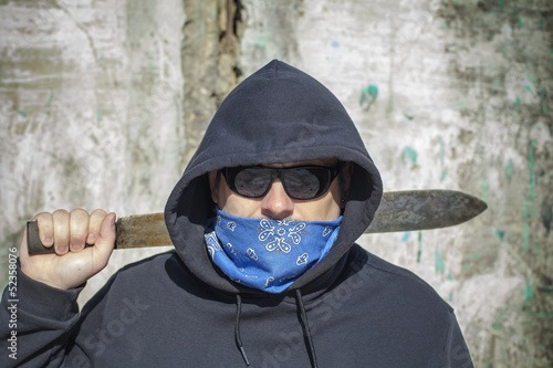 Man with a machete on a old wall background