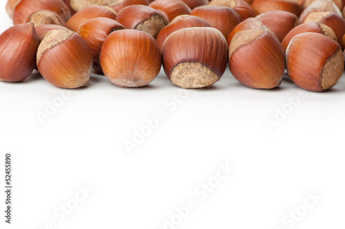 Unbroken hazelnuts on white surface