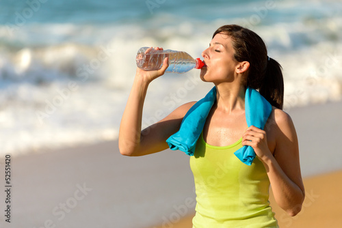 Fitness woman drinking water on summer