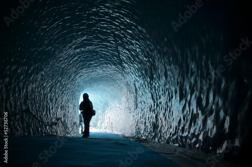 Human figure silhouette inside ice cave