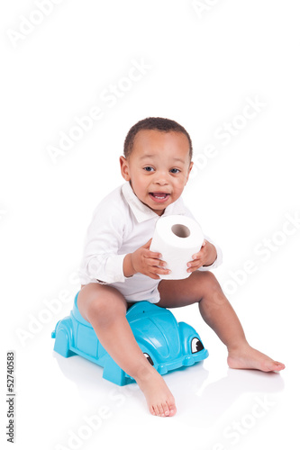 African child on potty play with toilet paper, isolated over whi