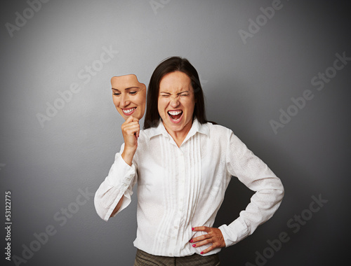 businesswoman hiding her anger behind the mask