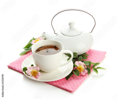 Cup and teapot of herbal tea with hip rose flowers, isolated