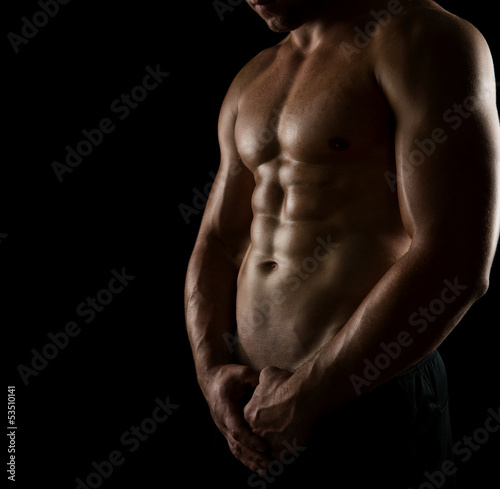 Close up of perfect male body isolated on black