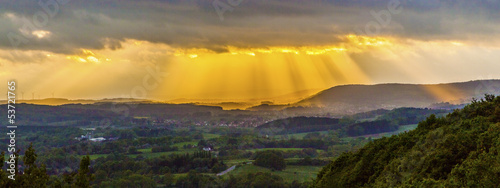 golden sunset at the mountains of the saarland with dark rain c
