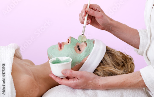 Beautician applying a thalasso face mask.