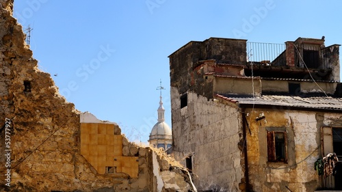 S.Sebastiano church' dome behind old and crumbling buildings