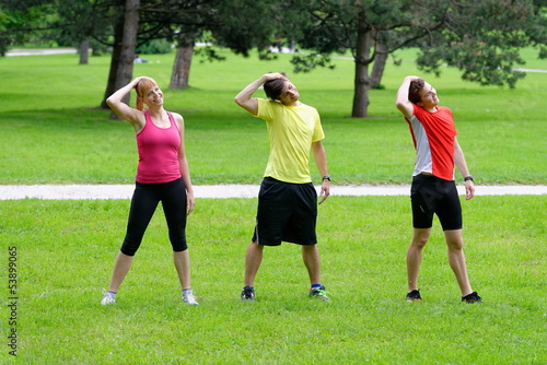 Group of three young health athletes doing stretching exercise