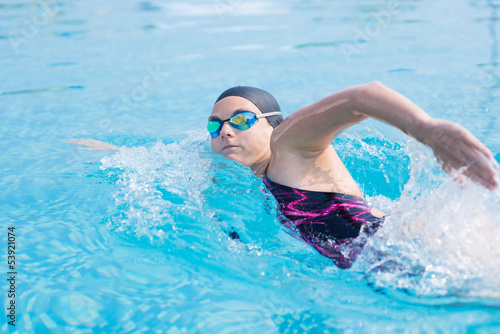 Woman in goggles swimming front crawl style