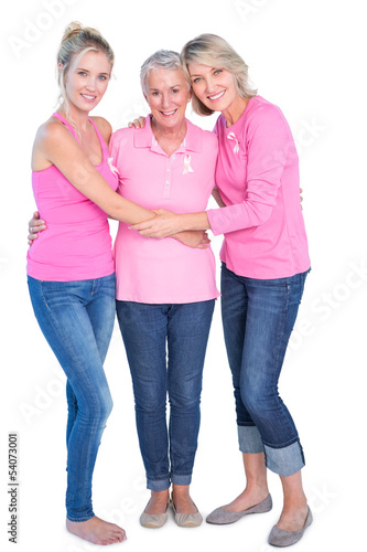 Cheerful women wearing pink tops and ribbons for breast cancer