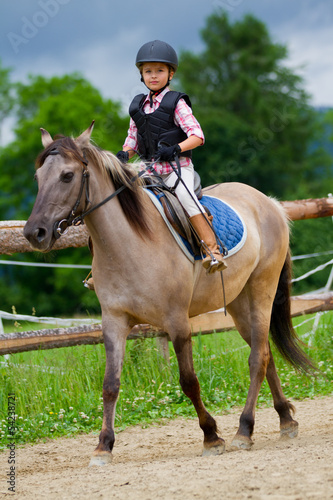 Horse riding - lovely girl is riding on a horse