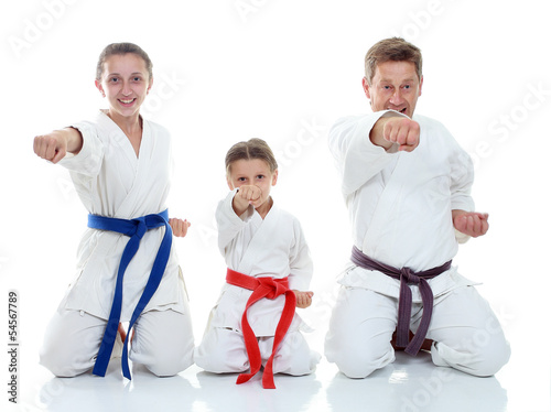 Dad with daughters in a ritual pose karate and beat his fist