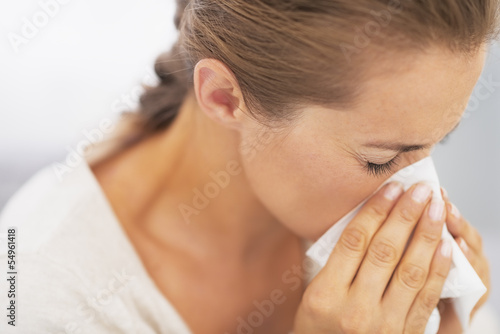 Woman blowing nose into handkerchief
