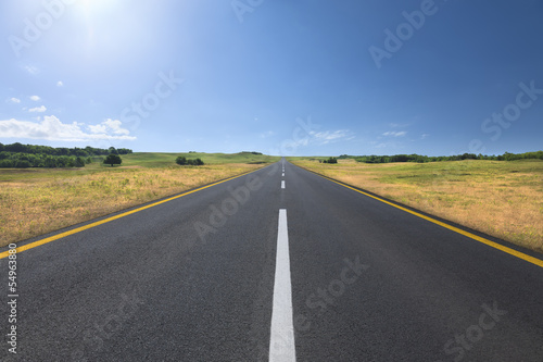 Driving on an empty road at bright sunny day