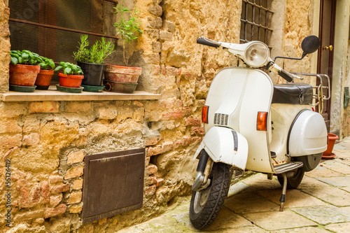 Vintage scene with Vespa on old street