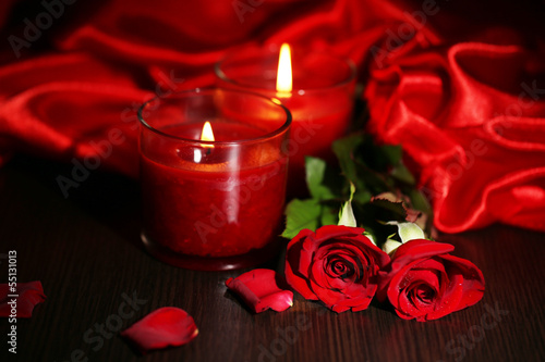 Beautiful romantic red candle with flowers and silk cloth,