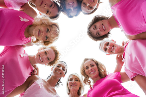 Cheerful women smiling in circle wearing pink for breast cancer