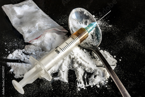 Drug syringe and cooked heroin on spoon