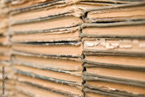 A lot of old, worn books are lying on top of each other.