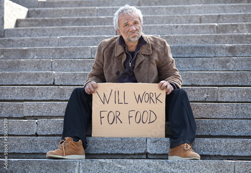 Will work for food. Depressed senior man sitting on stairs and h