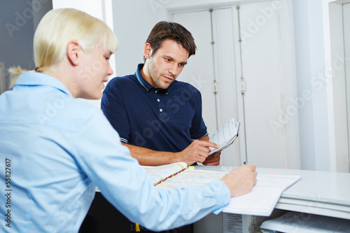 Man scheduling appointment at reception of dentist
