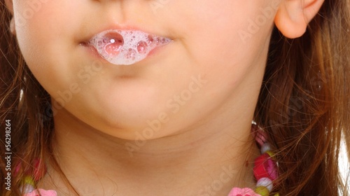 Close up little girl doing fun saliva bubbles