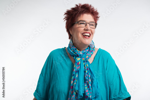 Happy smiling middle aged woman with red short hair and glasses.