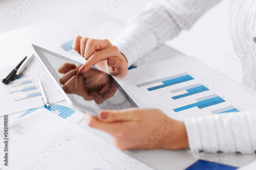 woman with tablet pc and chart papers