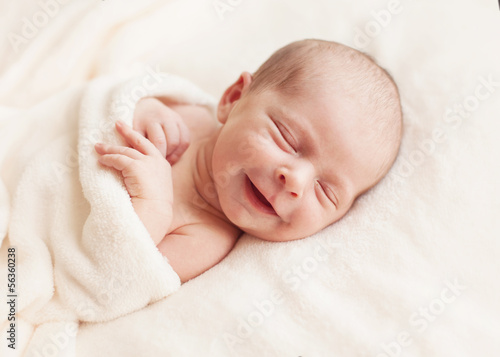 Newborn baby girl asleep on a blanket.