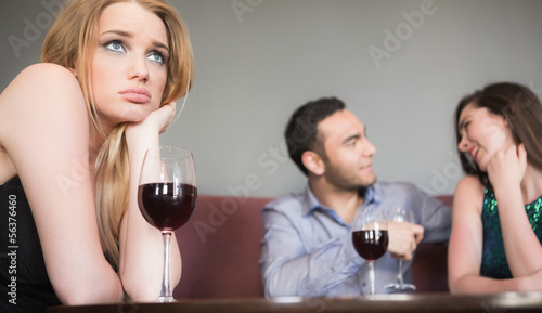 Blonde woman feeling jealous of couple flirting beside her