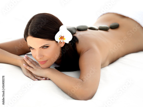Stone Massage. Beautiful Woman Getting Spa Hot Stones Massage. 