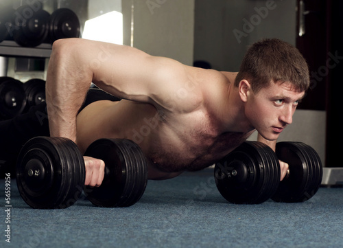 Handsome young muscular sports man in gymnasium