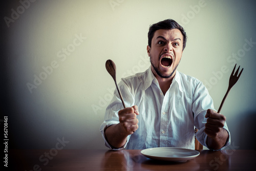 young stylish man with white shirt eating in mealtimes