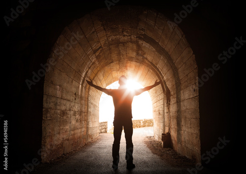 Man stands inside of old dark tunnel