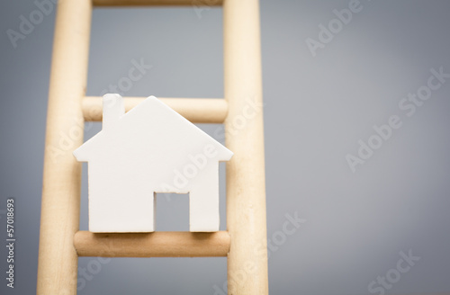 Model Houses On Rung Of Wooden Property Ladder