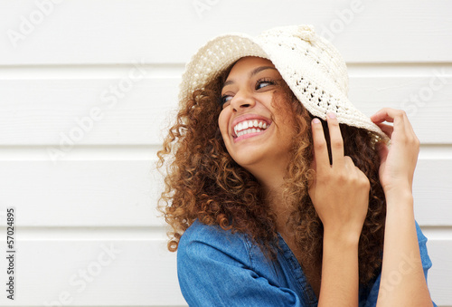 Beautiful young woman laughing and wearing summer hat