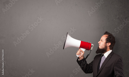 Guy shouting into megaphone on copy space background