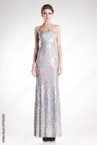 beautiful woman posing in long elegant silver sequins dress